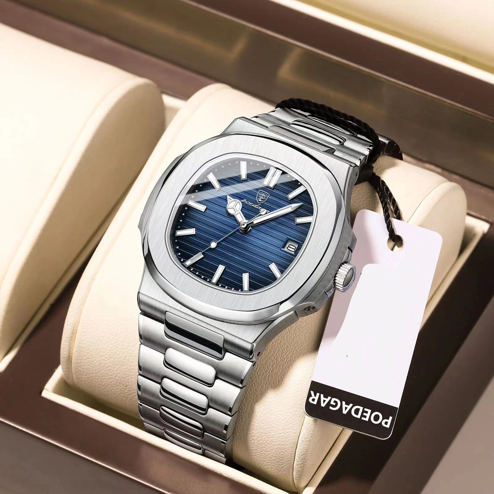 Silver watch with blue face and 'PODAGAR' tag on a beige cushion
